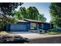 Charming one story home with landscaped front yard and a dark blue painted exterior at 332 Maple Dr, Frederick, CO 80530