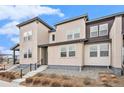 Stylish townhouse with modern design elements, featuring neutral siding, concrete steps, and minimalistic landscaping at 4755 Memphis St # 2, Denver, CO 80239