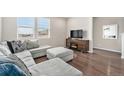 Comfortable living room featuring a large gray sectional sofa, fireplace, and plenty of natural light from the windows at 4755 Memphis St # 2, Denver, CO 80239