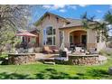Spacious backyard patio with stone accents, outdoor seating, and lush green lawn at 5055 Mcclure Ln, Castle Rock, CO 80108