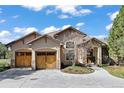 Inviting home showcasing a double wooden garage door, stone accents, and a beautifully landscaped front at 5055 Mcclure Ln, Castle Rock, CO 80108