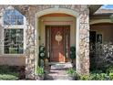Inviting front entrance with a wood door, stone columns, decorative plants, and elegant details at 5055 Mcclure Ln, Castle Rock, CO 80108