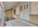 Close-up of the front porch, showcasing the home's secure, decorative screen door and brick accents at 3777 S Walden St, Aurora, CO 80013