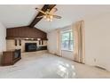 Living room with a striking brick fireplace, wood ceiling beams and ample natural light from a large window at 3777 S Walden St, Aurora, CO 80013