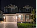 Inviting two-story home illuminated at night, featuring a cozy porch and manicured lawn at 821 Boulder Peak Ave, Erie, CO 80516