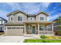 Charming two-story home with a welcoming front porch and well-maintained lawn and two car garage at 821 Boulder Peak Ave, Erie, CO 80516