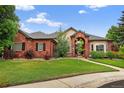 Beautiful red brick home with manicured lawn and arched entryway, creating a welcoming curb appeal at 5926 S Elkhart Ct, Centennial, CO 80016