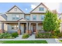 Beautifully maintained home with a covered front porch, lush landscaping, and vibrant green lawn at 5735 Boston St, Denver, CO 80238