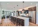 Spacious kitchen features a large island with seating, stainless steel appliances, and hardwood floors at 2599 S Cherokee St, Denver, CO 80223