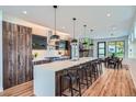 Kitchen with island, stainless steel appliances, hardwood floors, and open view of the dining area and staircase at 2599 S Cherokee St, Denver, CO 80223