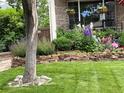 Charming front yard features a stone wall and blooming flowers at 4907 Fenwood Dr, Highlands Ranch, CO 80130