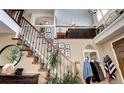Grand foyer with a staircase adorned with Gathering photos and natural light at 4907 Fenwood Dr, Highlands Ranch, CO 80130