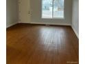 Bright living room featuring laminate flooring and a large window at 6392 S Hill St, Littleton, CO 80120