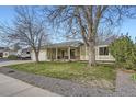 Street view of a charming ranch style home with mature trees and manicured lawn at 10661 W 104Th Ave, Broomfield, CO 80021