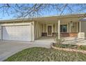 Inviting covered front porch featuring brick accents, lovely landscaping and two car garage at 10661 W 104Th Ave, Broomfield, CO 80021