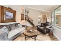 Bright living room with vaulted ceilings, a cozy seating arrangement, wood floors, and an open staircase to the second level at 6238 S Cherry Cir, Centennial, CO 80121