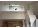 Bright living room featuring high ceilings, skylight, modern fan, and architectural columns at 16366 E Fremont Ave # 11, Aurora, CO 80016
