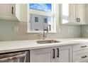 Modern kitchen featuring white countertops, a stainless steel sink, and white cabinets with black hardware at 5745 W 91St Ave, Westminster, CO 80031