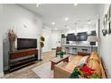 This living room features wood flooring, a comfortable leather couch, and an open floor plan into the kitchen at 6619 E Lowry Blvd # 101, Denver, CO 80230