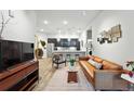 Comfortable living room with wood floors, a leather couch, and open layout into the kitchen and dining area at 6619 E Lowry Blvd # 101, Denver, CO 80230