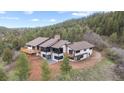 Beautiful exterior of a modern home with white siding, black trim, expansive windows, and a large deck at 7267 Comanche Ct, Larkspur, CO 80118