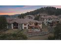 Aerial view of home with a tiered backyard, patio and balcony overlooking a wooded landscape at 1015 Nob Hill Rd, Evergreen, CO 80439