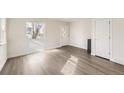 Bright, empty living room featuring wood-look floors, fresh paint, and a door to the outside at 4529 Barnacle Ct, Boulder, CO 80301