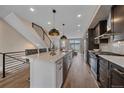 Stylish kitchen with island bar, stainless steel appliances, and modern pendant lighting at 2430 Ames St, Edgewater, CO 80214