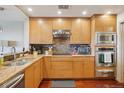 Modern kitchen with wood cabinets and granite countertops at 1900 E Girard Pl # 608, Englewood, CO 80113