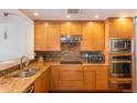 Well-equipped kitchen featuring wooden cabinetry, stainless steel appliances, and tile backsplash at 1900 E Girard Pl # 608, Englewood, CO 80113