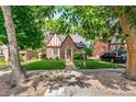Charming brick Tudor-style home with well-manicured lawn and mature trees at 3055 N Albion St, Denver, CO 80207
