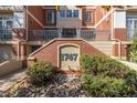 The building's front facade features a brick exterior, highlighted by the unit's address and surrounding greenery at 1747 N Washington St # C306, Denver, CO 80203