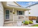 Inviting front porch with white railing and decorative plants adding curb appeal to the home at 11418 Macon St, Commerce City, CO 80640