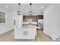 Modern kitchen featuring a large island with pendant lighting and stainless steel appliances at 9022 Spaulding St, Parker, CO 80134