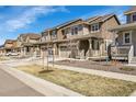 Row of craftsman style homes with covered front porches and stone accents on a sunny day at 9022 Spaulding St, Parker, CO 80134