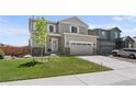 Charming two-story home with a well-manicured lawn and a two-car garage and stone accents at 14836 Jersey Dr, Mead, CO 80542