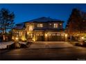Stunning two-story stucco home with stone accents, three-car garage and inviting curb appeal at twilight at 9445 Aspen Hill Cir, Lone Tree, CO 80124