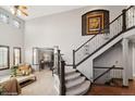 Grand foyer with soaring ceilings, elegant staircase, and views into the living room creates a striking entry at 9445 Aspen Hill Cir, Lone Tree, CO 80124