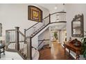 Elegant foyer with hardwood floors, staircase, and decorative wrought iron railing at 9445 Aspen Hill Cir, Lone Tree, CO 80124