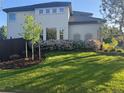 Lush front yard showcasing green grass, a small tree, and a beautiful flowerbed in front of the home's facade at 9445 Aspen Hill Cir, Lone Tree, CO 80124