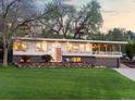 Beautiful home with a well-manicured lawn, stylish landscaping, and an inviting covered balcony area at 11900 W 18Th Ave, Lakewood, CO 80215