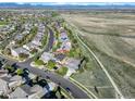 Expansive aerial view showcasing the neighborhood, the nearby walking path and mountains in the distance at 1909 Alpine Dr, Erie, CO 80516