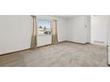 Bright room with neutral carpet and a large window at 1720 Pecos Way, Denver, CO 80221