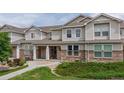 Attractive townhome exterior with manicured lawn, stone accents, and cozy covered entryway at 9758 Laredo St # 22D, Commerce City, CO 80022