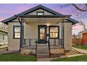 Charming home featuring an inviting front porch with decorative wrought iron railings and a well-maintained lawn at 2676 S Lincoln St, Denver, CO 80210