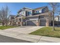 Two-story home with a three-car garage, porch, and well-maintained lawn at 20942 E Hampden Pl, Aurora, CO 80013