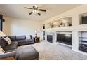 Cozy living room featuring a fireplace, built-in shelving, and comfortable seating at 20942 E Hampden Pl, Aurora, CO 80013