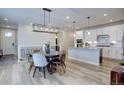 Dining area with modern light fixture and view of the kitchen with stainless appliances and island at 527 Felicity Loop, Castle Rock, CO 80109