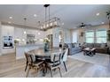 Open-concept layout featuring a kitchen with white cabinets, adjacent dining area, and cozy living room with comfortable seating at 527 Felicity Loop, Castle Rock, CO 80109