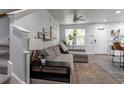 Comfortable living room with gray sofa, stylish rug, fan, and bright natural light at 2829 W 53Rd Ave # 104, Denver, CO 80221